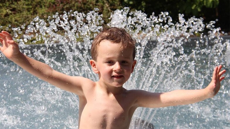 Der dreijährige Leon hat viel Spaß mit dem Pilz-Springbrunnen im Kinderbecken.
