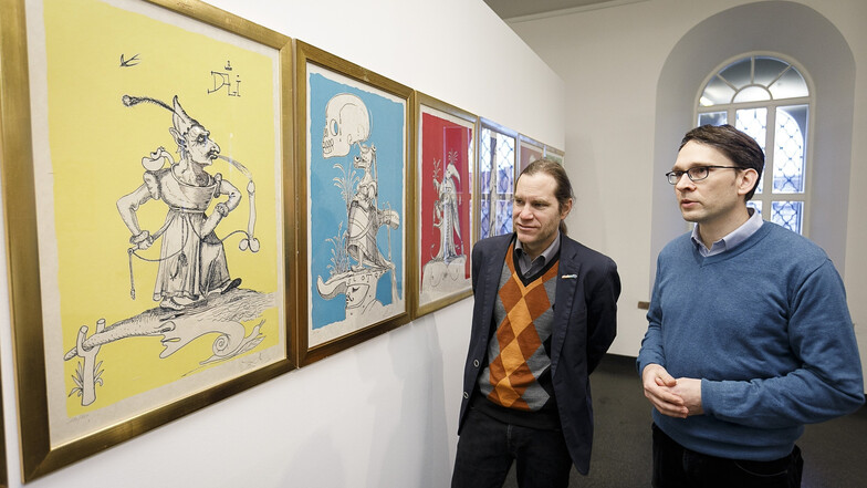 Viele sehr farbige Grafiken zeigen Kurator Kai Wenzel (r.) und Peter Knüvener in der Dalí-Ausstellung.