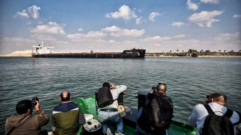 Ägypten, Ismailia: Fotografen machen Bilder von einem Schiff, das durch den Suezkanal fährt.