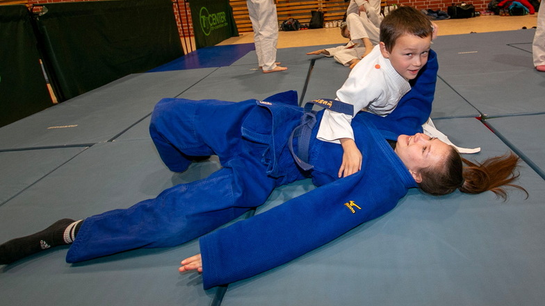 Der sechsjährige Felix gehört zu den Judoka und bringt die 16-jährige Josephine mit geübtem Griff zu Fall.