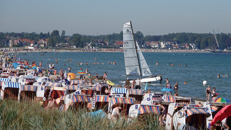 Sommerurlauber genießen das Sonnenwetter am Strand der Ostsee in Scharbeutz.