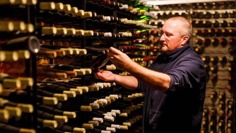 Jean-Christophe Lehnert steht im Keller seines Weingutes "Domaine Armand Gilg" und inspiziert alte Flaschen im "Archiv" des Weingutes.
