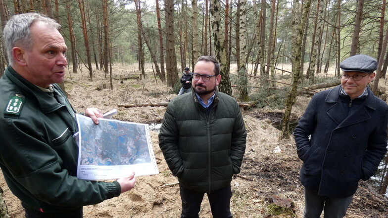 Franz Graf von Plettenberg (l.), Leiter des Bundesforstbetriebs Lausitz, erläutert Alexander Bonde von der DBU (M.) und Umweltminister Wolfram Günther den Umfang des Vernässungsprojektes im Daubaner Wald.