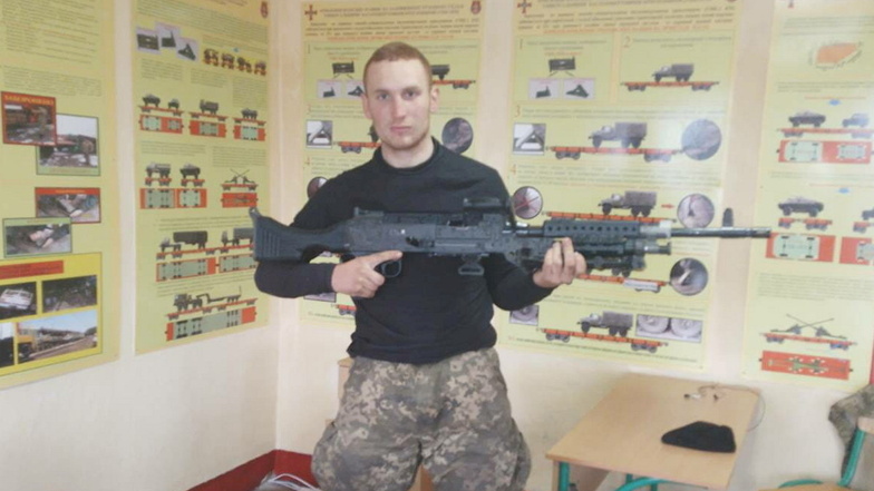 Yasin Bläser posiert während der Ausbildung in der Ukraine mit einem Maschinengewehr.