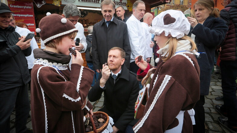 Na, wie schmeckts? Sachsen Ministerpräsident Michael Kretschmer (Mitte) kostet mit den Pfefferkuchenkindern Mathis (l.) und Kristina die Pulsnitzer Spitzen.