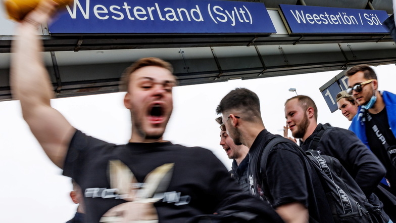 Eine Touristengruppe feiert auf dem Bahnhof von Westerland auf Sylt die Ankunft.