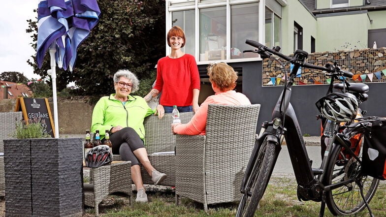 Anett Börner (Mitte) empfängt zwei Radtouristinnen aus Dresden, die auf ihrer mehrtägigen Tour auf dem Elberadweg in Lorenzkirch Rast machen.