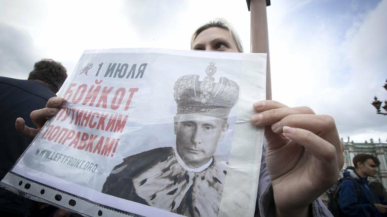 Eine Frau hält bei einem Protest gegen die Verfassungsänderung auf dem Palastplatz in St. Petersburg ein Plakat mit dem Bild des russischen Präsidenten als König hoch.