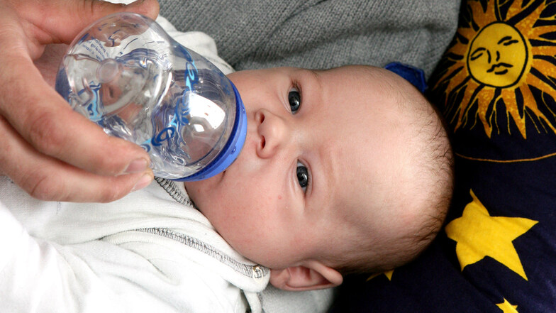 Ein Vater gibt seinem sieben Wochen alten Sohn eine Nuckelflasche gefüllt mit Tee.