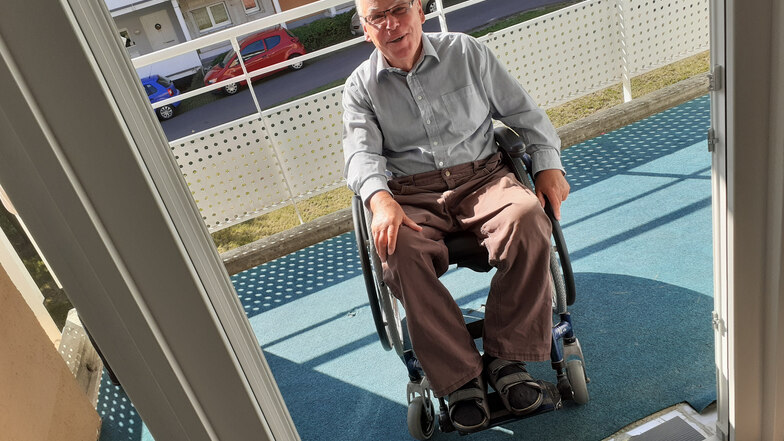Günter Feder auf einem Balkon einer sanierten G 22-Wohnung: Für Rollstuhlfahrer hat sich der Zugang wesentlich verbessert.