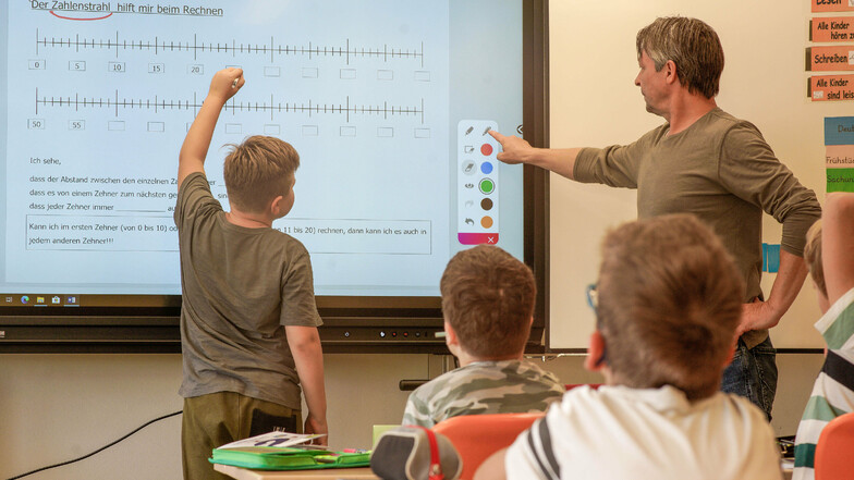 Mathelehrer Michael Janze (r.) erklärt seinen Schülern den Zahlenstrahl an einer interaktiven Tafel.