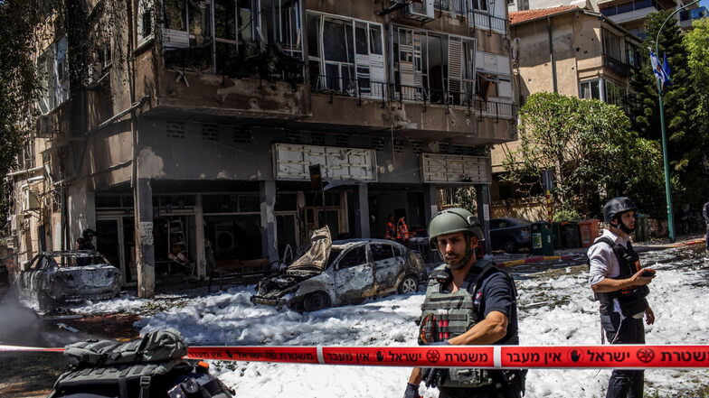 Israelische Einsatzkräfte vor einem Wohnhaus, das zuvor von einer Rakete der islamistischen Hamas getroffen wurde.