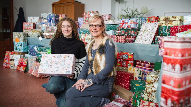 Jugendliche Mia (l.) und Andrea Winkler vom Jugendhilfeprojekt der Volkssolidarität Riesa-Großenhain inmitten von reichlich 150 gespendeten Geschenk-Päckchen.