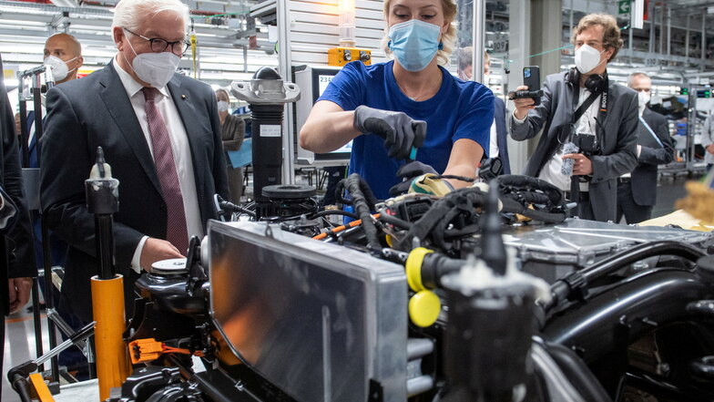 Bundespräsident Frank-Walter Steinmeier informiert sich am Arbeitsplatz von Jessica Göhl, Mitarbeiterin im VW Werk Zwickau, über die Montage des Antriebsstrangs für die Elektrofahrzeuge ID.3 und ID.4.