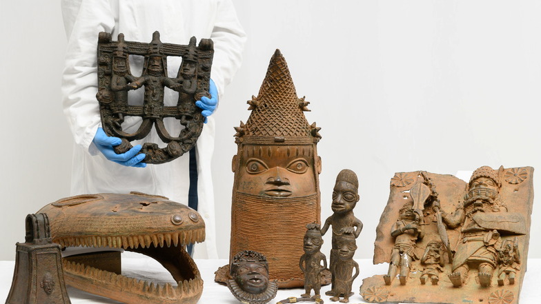 Figuren aus Bronze, ein Armreif und ein Schmuckanhänger aus dem historischen Königreich Benin aus der Zeit vor 1897, hier in einem Arbeitsraum des Museums für Völkerkunde Dresden.