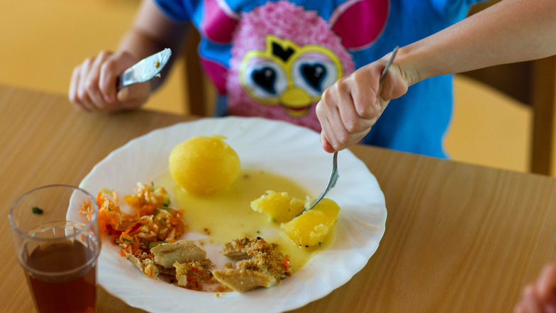 Ein Mädchen isst in einer Kindertagesstätte zu Mittag. In Gröditz ist das Essen seit Jahresanfang teurer geworden.