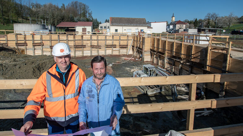 Reiner Müller (rechts), Technischer Leiter beim AZV Untere Zschopau, und Polier Thomas Richter stehen vor der riesigen Baugrube im Klärwerk Hartha.