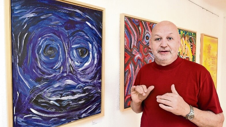 Der Freitaler Alexander Jesau steht im Einnehmerhaus Freital vor den Bildern seiner ersten Ausstellung, links hängt „blue ghost“, der blaue Geist.