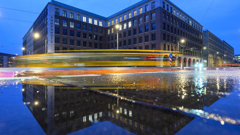 Die Annenhöfe in Dresden spiegeln sich am Abend in einer Pfütze, während eine Straßenbahn vorbei fährt. Der Softwarekonzern SAP dort einen neuen Campus  eröffnet.
