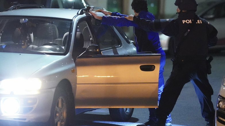 Schwerbewaffnete Polizisten kontrollieren in der Wiener Innenstadt an einem Auto eine Person.