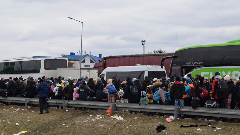 Hunderte Flüchtlinge sind auch zu Fuß unterwegs. Das Motto von Flixbus im Hintergrund, "lux & relax", wirkt verheißungsvoll und etwas zynisch zugleich.