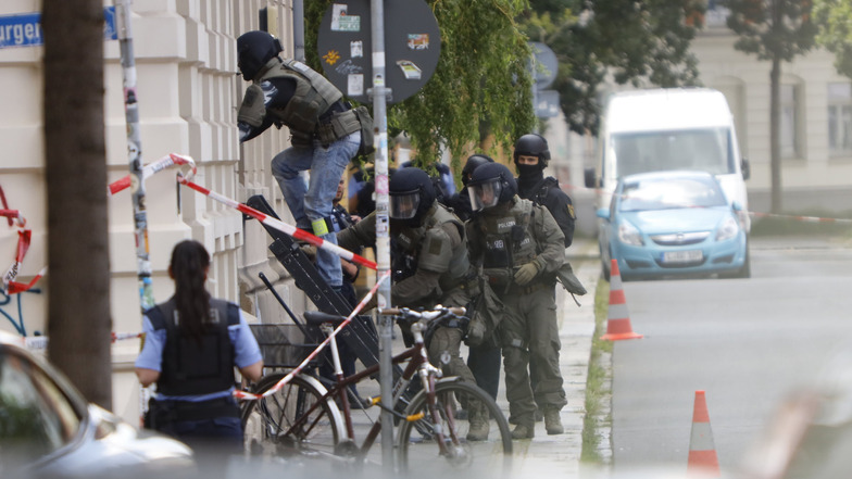 Polizisten stehen während des SEK-Einsatzes vor dem Wohnhaus des aggressiven Mieters.