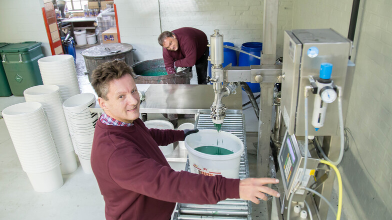 Geschäftsführer Michael Schäfer (hinten) und Mitarbeiter Thomas Krämer sind froh, dass die neue automatische Abfüllmaschine endlich in Betrieb gegangen ist. Damit steigt die Produktivität in der Nieskyer Lackfabrik auf das Vierfache.