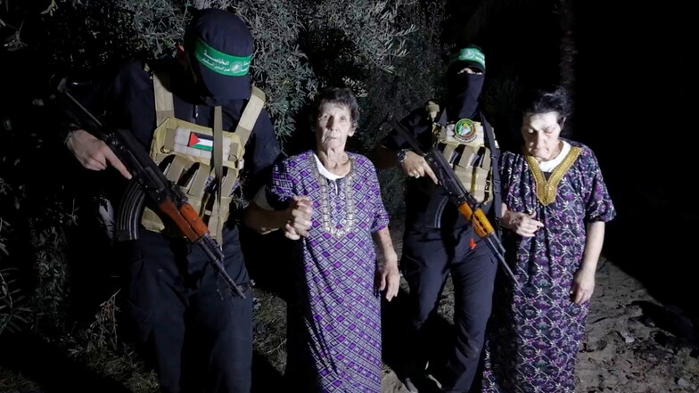 Dieses Bild stammt aus einem Video, das die Al-Qassam-Brigaden auf ihrem Telegramm-Kanal veröffentlicht haben. Es zeigt die beiden Geiseln Yocheved Lifschitz und Nurit Cooper, die von der Hamas eskortiert werden, während sie dem Roten Kreuz übergeben werd