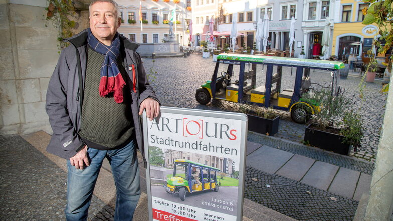 Artur Gawryluk steht mit seinem Werbeschild vor dem Hotel Emmerich am Görlitzer Untermarkt. Sein Elektromobil ist ein Hingucker.