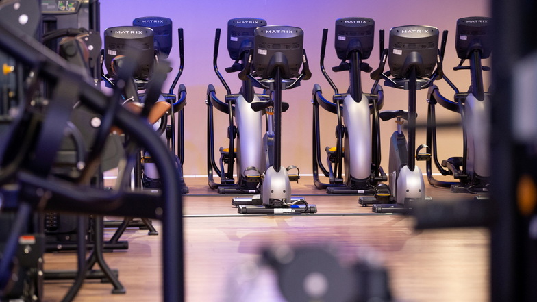 Unbenutzte Trainingsgeräte stehen in einem geschlossenen Fitnessstudio.