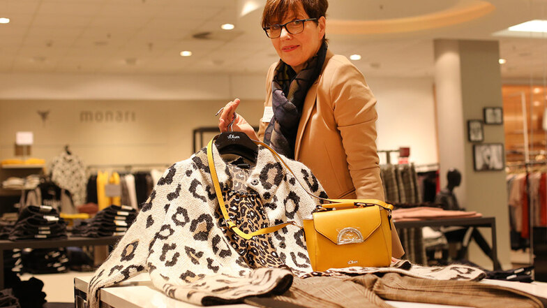 Kerstin Weigel zeigt im Modehaus Mein Fischer eine modische Kombination für Damen im Herbst, mit Leopardenprint und Farbtupfer durch die gelbe Tasche. Dazu eine karierte Hose.