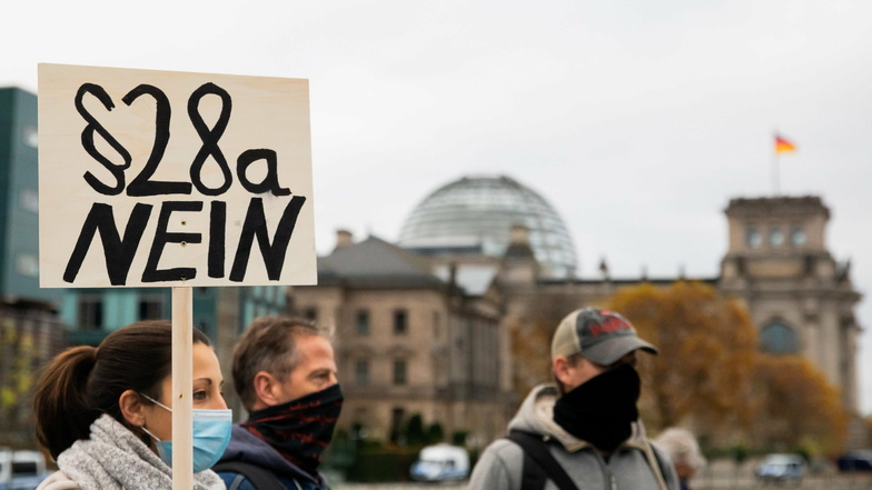 Teilnehmer einer Demonstration gegen die Corona-Einschränkungen der Bundesregierung stehen nahe dem Reichstagsgebäude auf der Marschallbrücke. Zeitgleich wurde die Neufassung des Infektionsschutzgesetzes beschlossen.