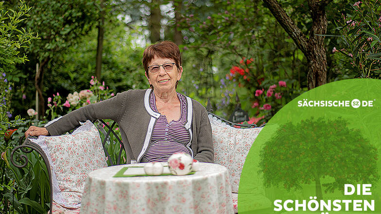 Als würde man im Wald sitzen: Hannelore Knöfel macht es sich auf einer Bank in ihrem Garten in Großröhrsdorf bequem. Hinter ihr rauschen die Bäume.