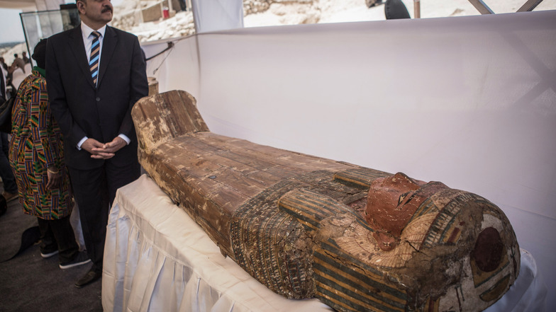 Ein Mann steht neben einem Holzsargdeckel, der Teil des neu entdeckten Pharaonengrabs ist. Das Grab stammt nach Angaben ägyptischer Behörden aus der 18. Dynastie.