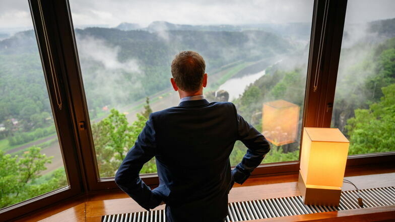 Michael Kretschmer (CDU), Ministerpräsident von Sachsen, steht vor Beginn der auswärtigen Kabinettssitzung auf der Bastei im Nationalpark Sächsische Schweiz im Tagungssaal und schaut aus dem Fenster auf das obere Elbtal.