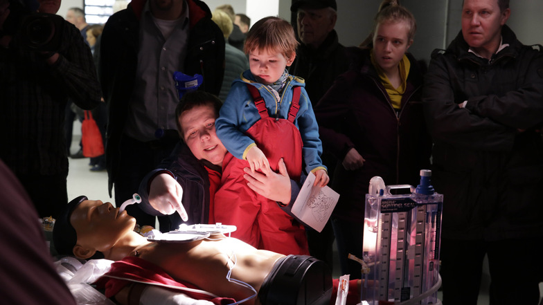 Annekathrin Rast-Mütze aus Zürich zeigt ihrer Tochter Tanja die Testpuppe im neuen Schockraum der Notaufnahme in Radebeul