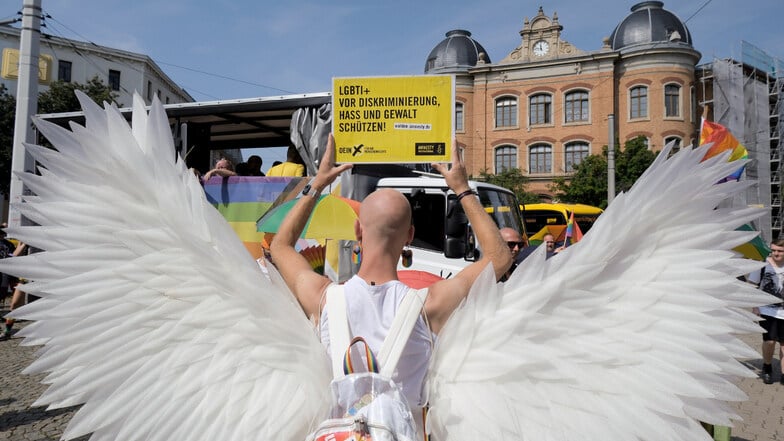 Ein Teilnehmer des Christopher Street Day (CSD) hält ein Schild mit der Aufschrift "LGBTI+ vor Diskriminierung, Hass und Gewalt schützen".