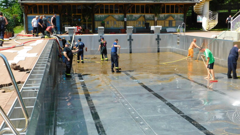Freiwillige Helfer und Kameraden der Feuerwehr reinigten einen Tag nach den Überschwemmungen das Freibad "Wasserwelt" in Steinigtwolmsdorf.