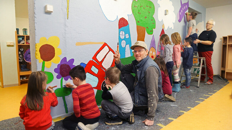 Künstler Sebastian Bieler (4. v.l.) aus Großenhain gestaltet mit den Kindern der Gröditzer Kita Buratino eine Wand.