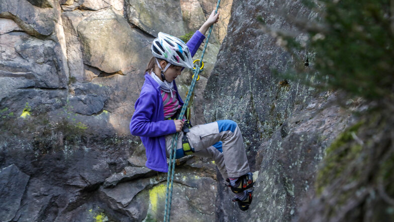 Die neunjährige Maria aus Zittau klettert am Habicht in den Jonsdorfer Mühlsteinbrüchen. Dieser Felsen besteht aus härterem Gestein. Abbrüche sind hier unwahrscheinlich. Aber das ist nicht überall so.