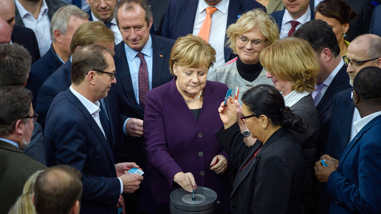 Bundeskanzlerin Angela Merkel (CDU) gibt am Freitag gemeinsam mit anderen Abgeordneten ihre Stimmkarte zum Haushalt 2020 ab.