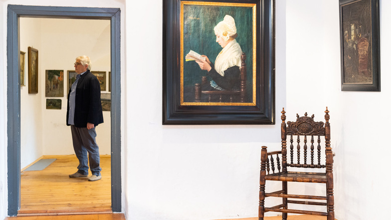 Lutz Käubler, Urenkel und Nachlassverwalter des Malers Paul Poetzsch, hat die Ausstellung im Schloss Lauenstein eingerichtet. Im Vordergrund das Gemälde „Lesendes Mädchen“ von 1901.