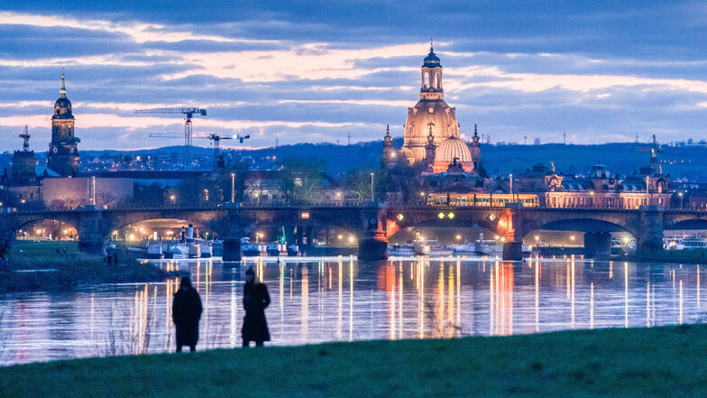 Ziemlich allein: Zwei Personen spazieren an der Elbe in Dresden. So wie bundesweit gelten auch in Sachsen seit Montag strikte Ausgangsregeln.
