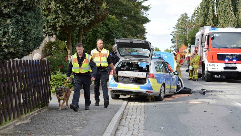 Ende der Verfolgungsjagd von Dresden bis ins Oberland: Ein Polizeiauto hat Totalschaden, die Feuerwehr muss anrücken. Die Polizei sucht den Flüchtigen mit einem Fährtenhund.