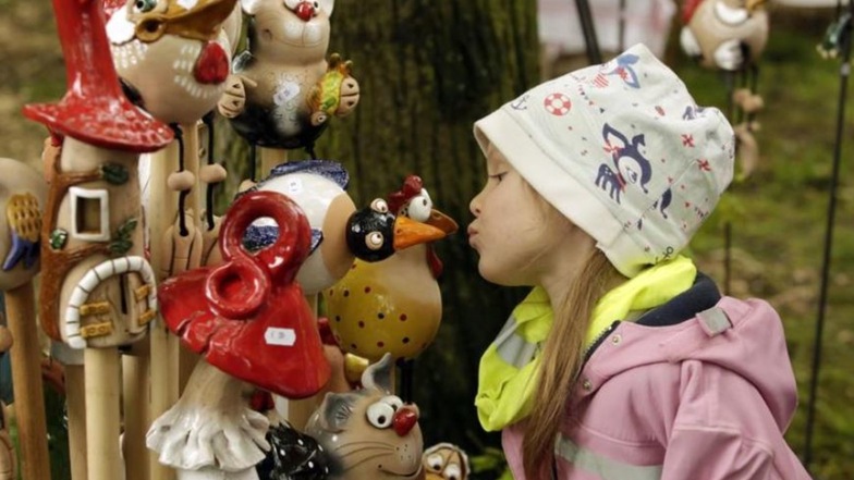 Klein Mia aus Elstra geht auf Tuchfühlung mit Keramikfiguren aus der litauischen Töpferei Artaga, die zum dritten Mal am Markt teilgenommen hat.