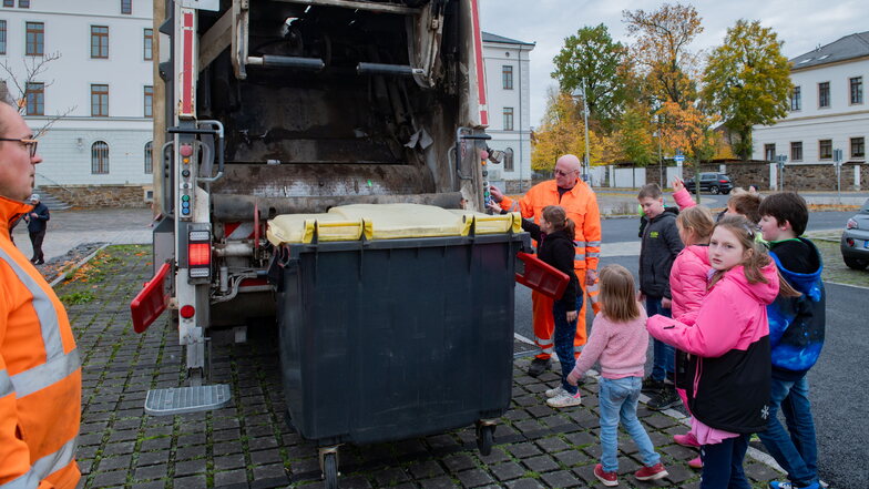 Die Mitarbeiter von Remondis zeigen den Kindern der dritten Klasse der  Schule mit dem Förderschwerpunkt Lernen auf dem Großenhainer Remonteplatz die Funktionsweise des Müllautos.