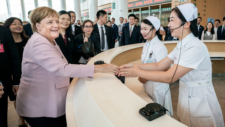 Bundeskanzlerin Angela Merkel (CDU, 2.v.l.) wird von Krankenschwestern am Eingang des deutsch-chinesischen Freundschaftskrankenhaus Tongji begrüßt.