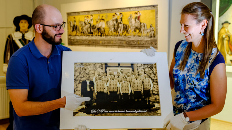 Nicht ohne Schmunzeln betrachten die Mitarbeiter Magdalena Lorenz und Robert Rösler im Heimatmuseum Radeburg die Exponate zur Sonderausstellung 60 Jahre städtische Narrenpolizei.