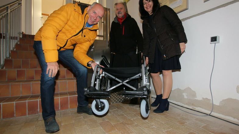 Brit Borgmann (rechts) vom gleichnamigen Sanitätshaus übergibt an Jörg Lippert und Alfred Klepzig vom Pferdebahnverein einen Rollstuhl. Mit dem kann der Hublift problemlos genutzt werden.