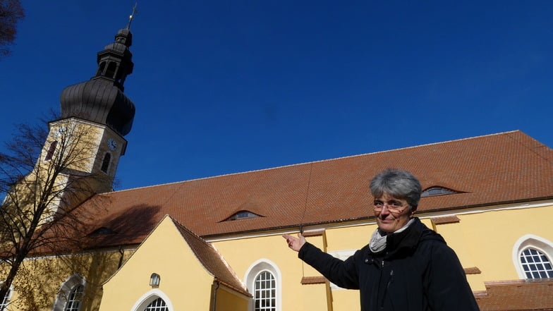 Pfarrerin Susanne Aechtner freut sich über das nach der Sanierung wieder makellose Erscheinungsbild der Neschwitzer Kirche.